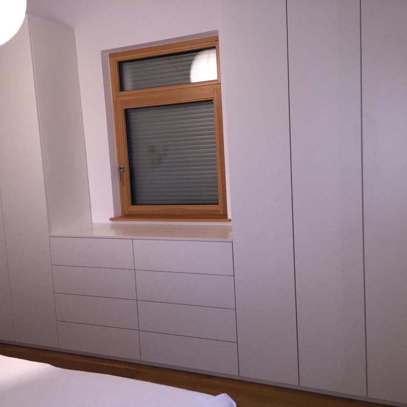 Passgenauer Kleiderschrank um Fenster mit weißen Fronten