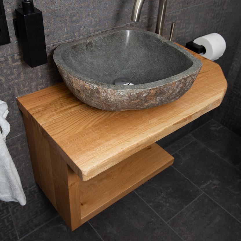 Rustikaler Waschtisch aus Altholz mit Natursteinbecken und dunkler Wandverkleidung.