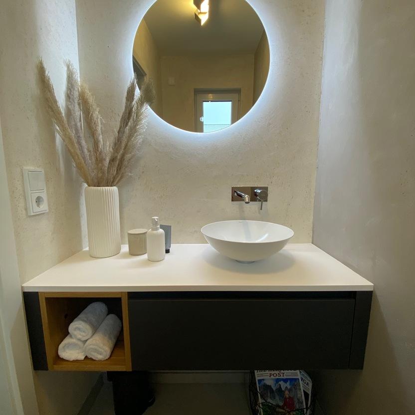 Modernes Gästebad mit rundem Spiegel, Aufsatzwaschbecken und Waschtischunterschrank in Schwarz-Eiche.