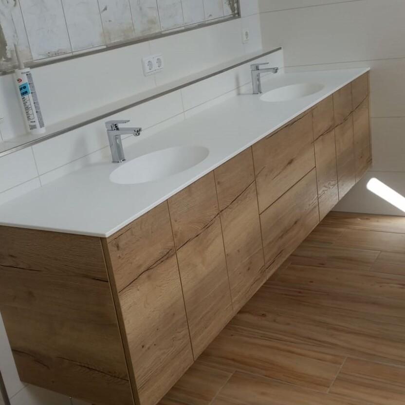 Doppelwaschtisch mit Holzunterschrank und weißen Waschbecken in einem modernen Badezimmer mit Parkettboden