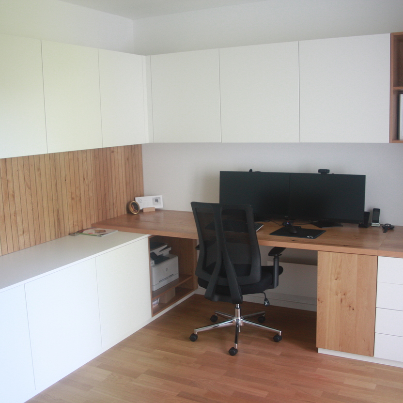 Büromöbel nach Maß mit Eckschreibtisch, weißem Stauraum, Holzarbeitsplatte und Oberschränken im modernen Stil.