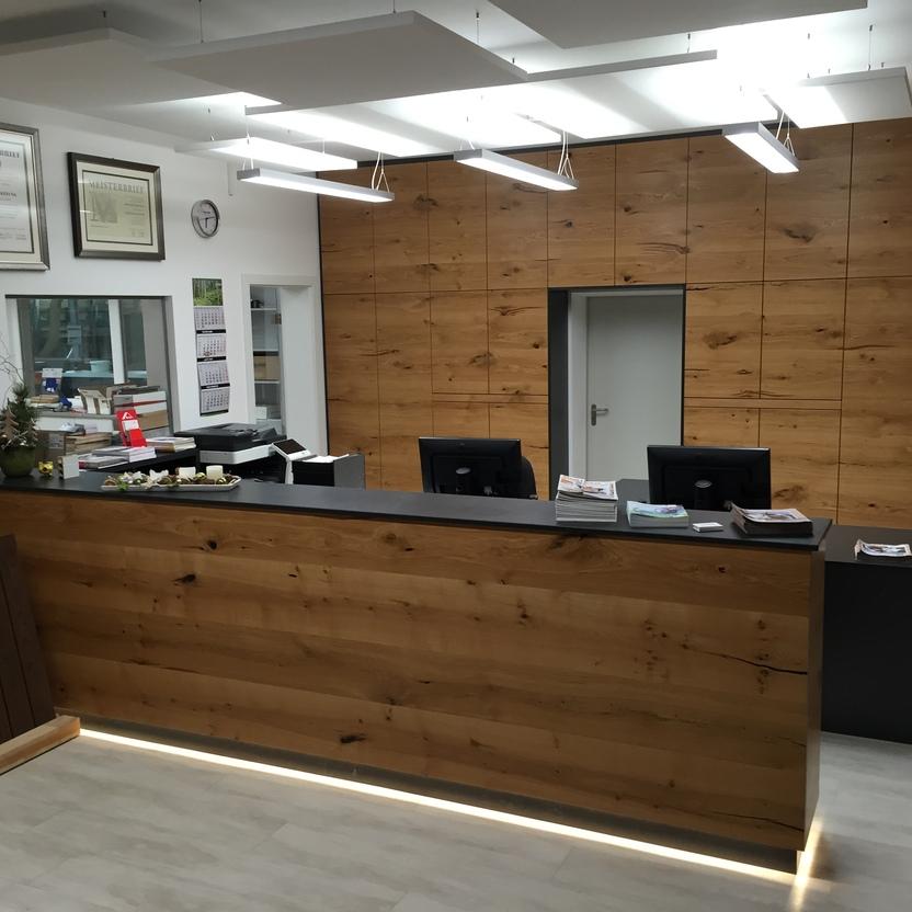Büromöbel nach Maß mit großer Empfangstheke und wandbündigem Aktenschrank aus Eiche in modernem Büro