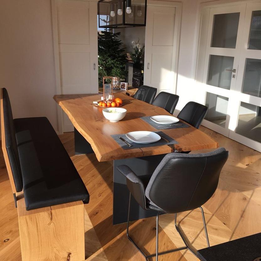 Ein helles Esszimmer mit einem großen Holztisch, maßgefertigten Schränken und modernen Stühlen, perfekt für den Innenausbau nach Maß.