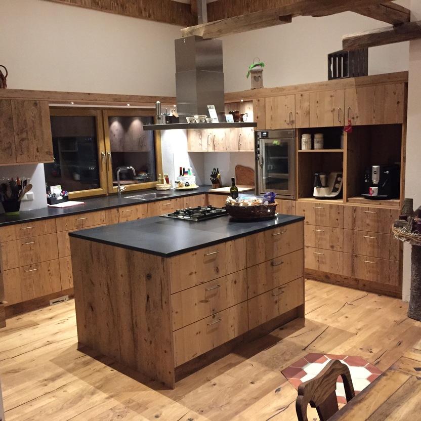 Ländliche Küche mit Holzschränken, zentraler Insel und Holzbalken