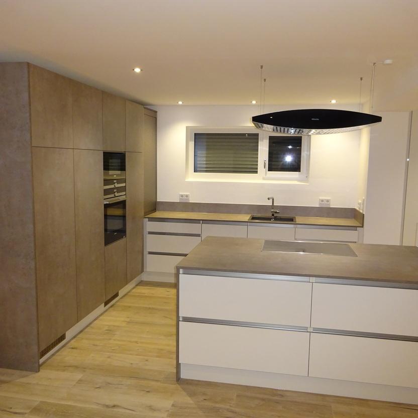 Moderne Küchenmöbel mit Kochinsel, matten Fronten in Beige und großflächigen Schränken in Betonoptik