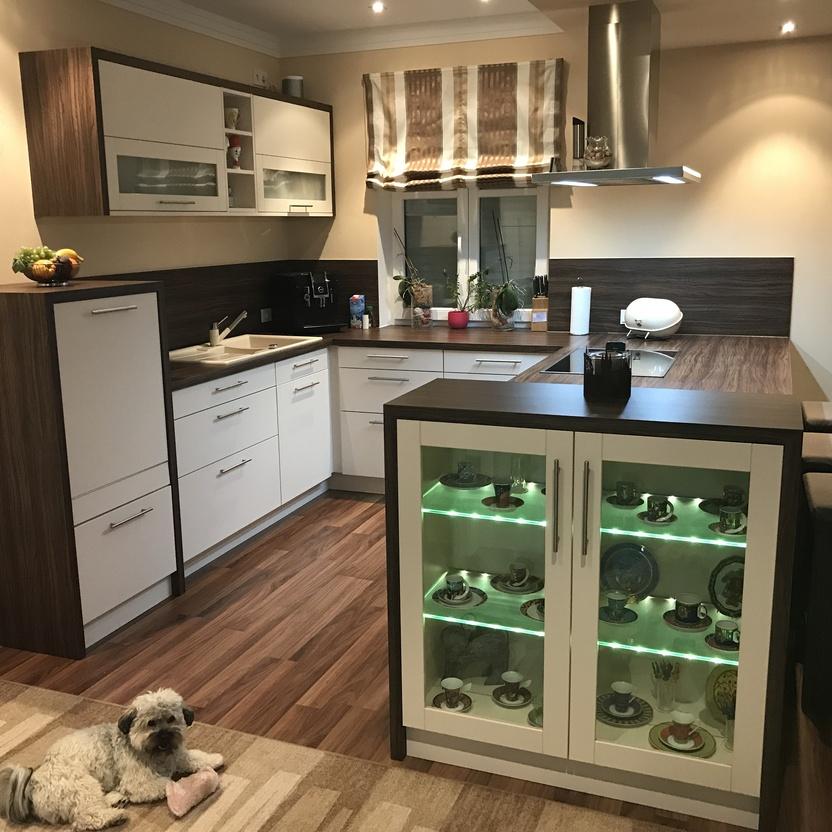 Hund liegt auf Teppich in Küche mit weißen Schränken, Holzakzenten und Insel