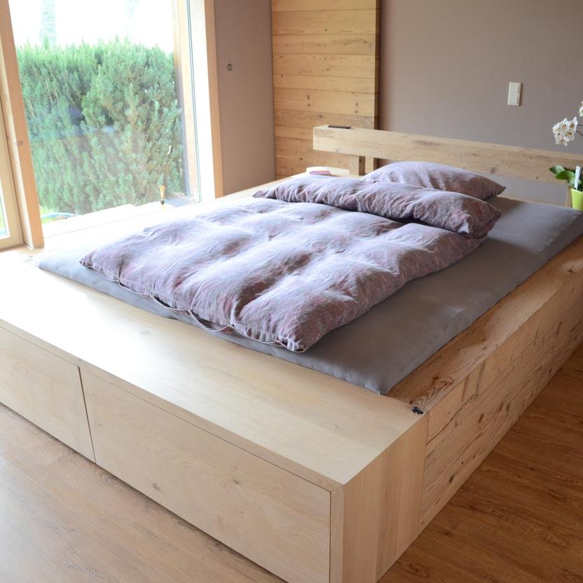 Massives Holzschlafzimmer mit Bettkästen, großem Fenster und gemütlicher Atmosphäre.