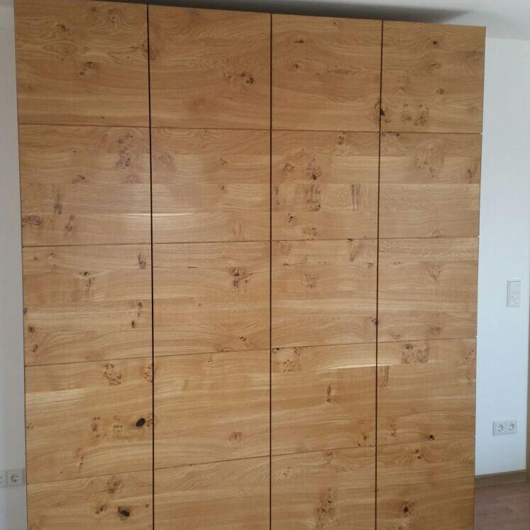 Moderner Kleiderschrank aus massivem Eichenholz mit markanter Maserung und glatten Fronten.