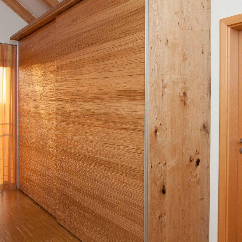 Großer Schiebetürenschrank aus Eichenholz mit klarer Maserung und natürlicher Oberfläche.