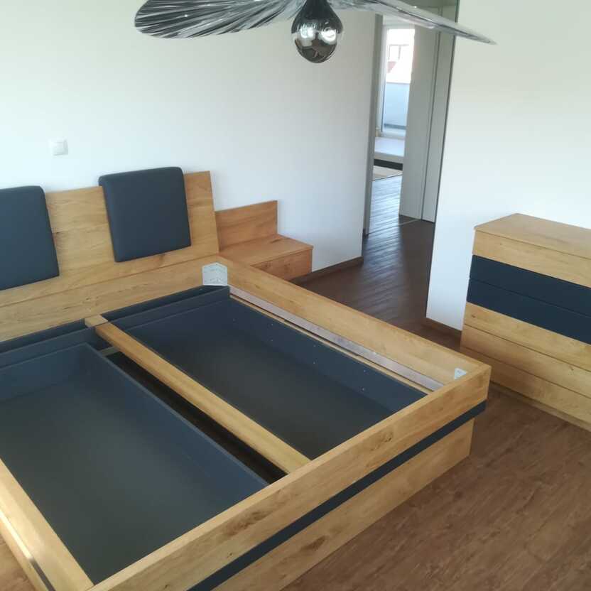 Schlafzimmermöbel aus Eiche mit Bettkasten, grauen Akzenten und moderner Kommode.