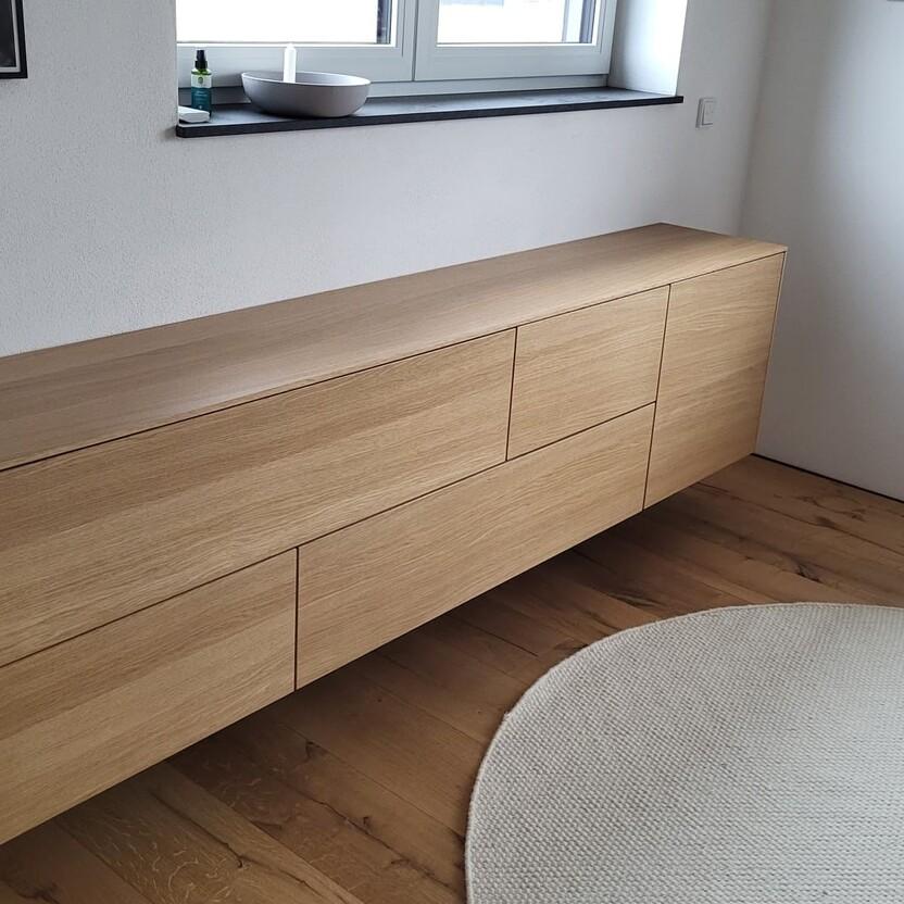 Schwebendes Sideboard aus astfreier Eiche mit klarer Linienführung und minimalistischer Form.